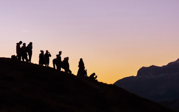 Group of hikers silhouetted on a ridge at sunset